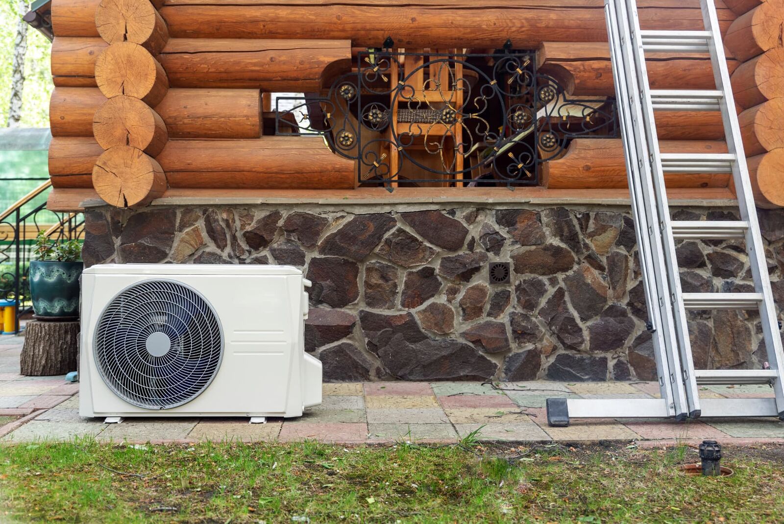 Wärmepumpe auf einem Sockel vor einem Haus